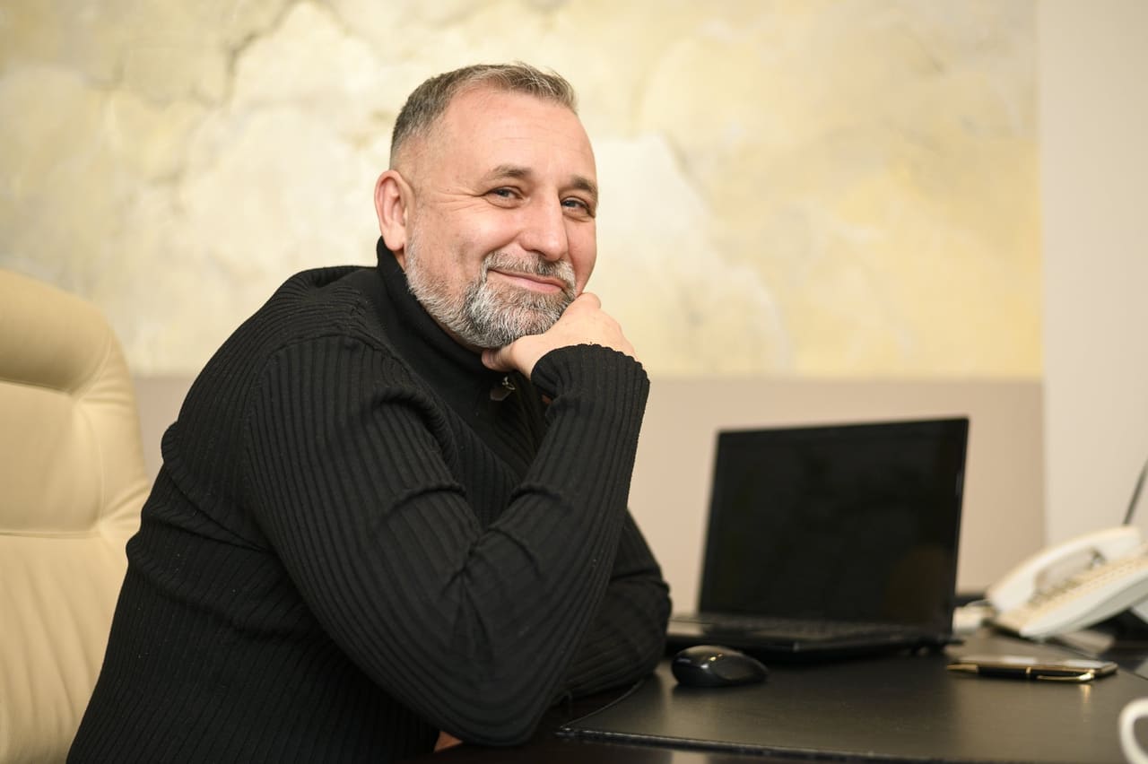 An owner at his desk, smiling